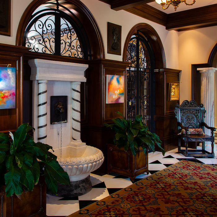Elegant foyer with abstract art pieces lit by Plug-in Micro Series lights, featuring classic architecture and stylish furnishings