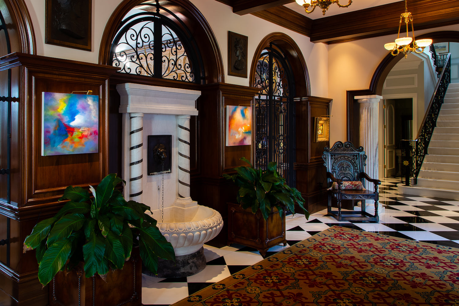 Elegant foyer with abstract art pieces lit by Plug-in Micro Series lights, featuring classic architecture and stylish furnishings