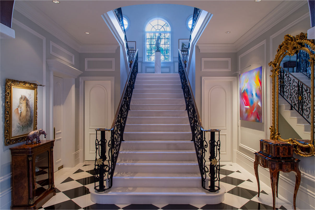 Elegant staircase with decorative railings and vibrant artwork illuminated by high-CRI picture light