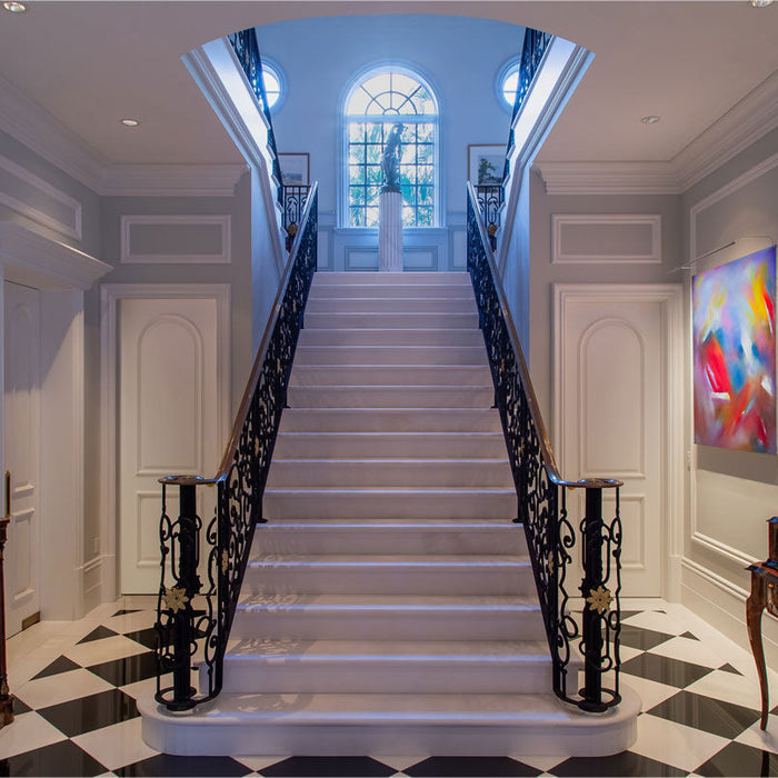 Elegant staircase with decorative railings and vibrant artwork illuminated by high-CRI picture light